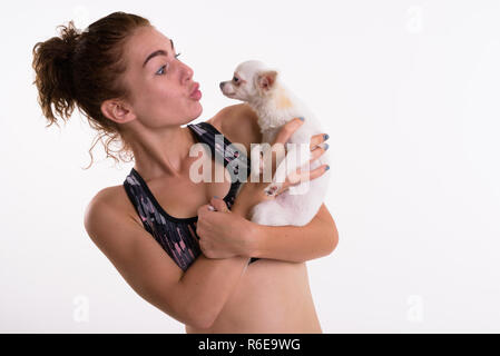Studio shot of beautiful teenage girl holding while kissing cute Stock Photo