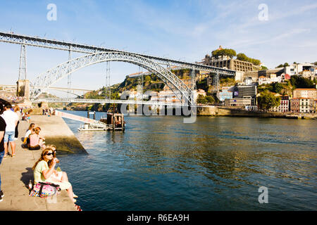 Porto, Portugal - September 16, 2018 : People enjoying the beautiful sunny day on the banks of the Douro river near the bridge Luiz I on the quay of R Stock Photo