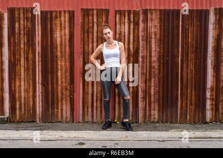 Young beautiful teenage girl standing while posing against old r Stock Photo