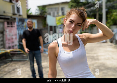 Young beautiful teenage girl making funny face with young bearde Stock Photo