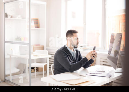 Man using Smartphone at Work Stock Photo