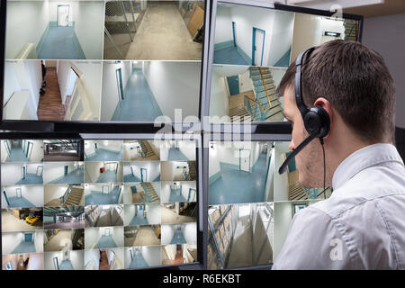 Operator Looking At Multiple Camera Footage On Computer Stock Photo