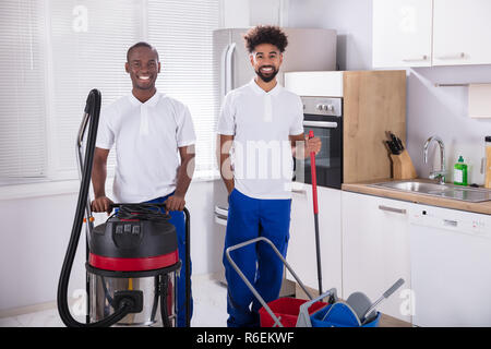 Portrait Of Two Happy Male Janitor In The Kitchen Stock Photo