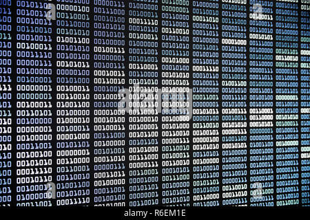 binary code on display screen. white blue light green colors number one and zero lined in rows on computer monitor. cyber data connection and security Stock Photo