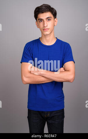 Young handsome Persian teenage boy with arms crossed Stock Photo