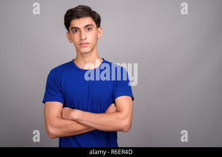 Young handsome Persian teenage boy with arms crossed Stock Photo