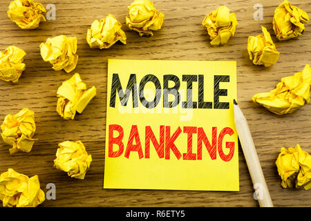 Word, writing Mobile Banking. Business concept for Internet Banking e-bank written on sticky note paper on the wooden background. Folded yellow papers on the background Stock Photo