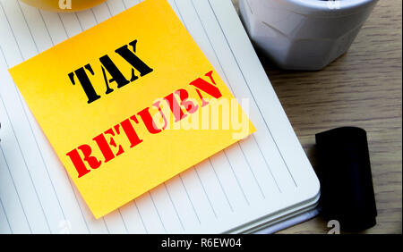 Writing text showing Tax Return. Business concept for Accounting Money Return written sticky note empty paper, Wooden background with copy space, Coffee and marker Stock Photo