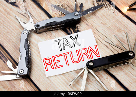 Conceptual hand writing text caption inspiration showing Tax Return. Business concept for Accounting Money Return Written on sticky note wooden background with pocket knife Stock Photo