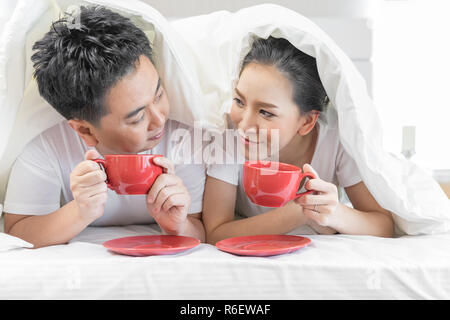 Couples having breakfast on bed Stock Photo