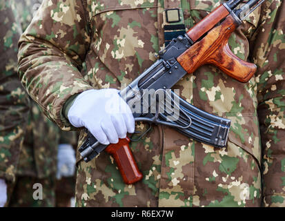 Soldier dressed in a white glove with his hand on the gun. Armed soldiers take part at a military parade.Armed soldiers. Stock Photo