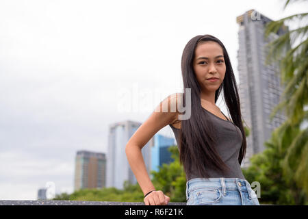 Portrait of a teenage girl drying a bikini bottom on a clothesline