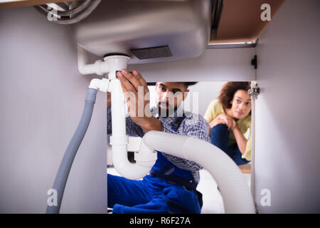 Close-up Of A Plumber Fixing Sink Pipe Stock Photo