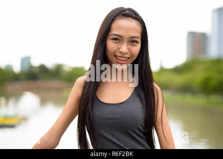 Happy young beautiful Asian woman smiling at the park Stock Photo