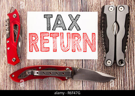 Conceptual hand writing text caption inspiration showing Tax Return. Business concept for Accounting Money Return Written on sticky note wooden background with pocket knife Stock Photo