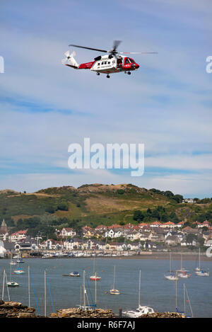 Vertical view of the coastguards helicopter flying across the Conwy river. Stock Photo