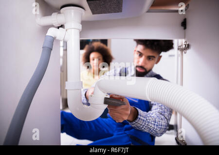 Close-up Of A Plumber Fixing Sink Pipe Stock Photo