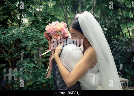 Wedding couple, groom and bride, woman and man, hug each other and hold bouquet flower, love and valentine concept Stock Photo