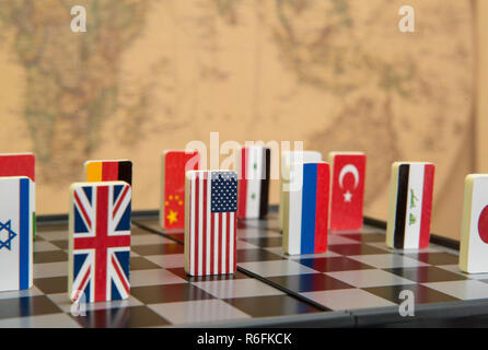 symbols of countries on the chessboard against against the background the political map of the world. Conceptual photo, political games. Stock Photo