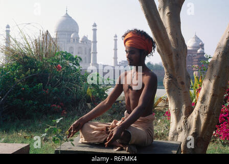 man sitting in yoga posture near at Taj mahal Seventh Wonder of The World, Agra, Uttar Pradesh, India Stock Photo
