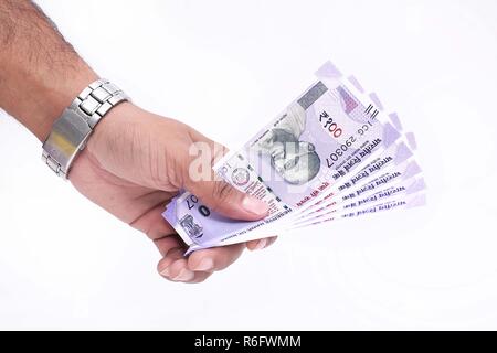 100 Indian currency in hand. Isolated on the white background Stock Photo