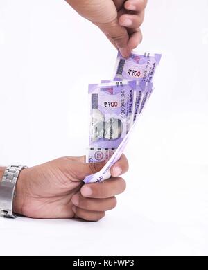 Picture of hand is holding Indian 100 rupee currency. Isolated on the white background. Stock Photo