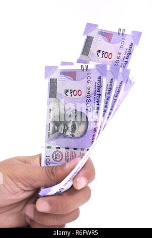 Hand with new Indian currency notes. Isolated on the white background. Stock Photo