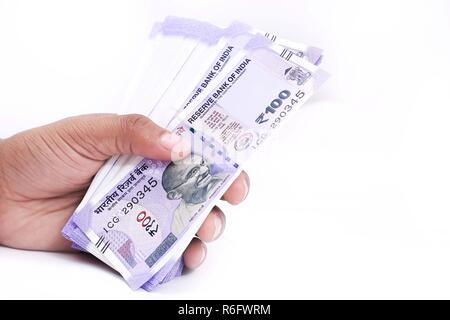 Picture of hand with new Indian currency notes. Isolated on the white background. Stock Photo