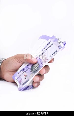 Portrait of hand with new Indian currency notes. Isolated on the white background. Stock Photo