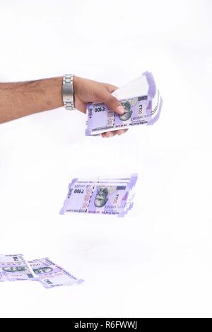 Picture of hand is throwing new Indian currency. Isolated on the white background. Stock Photo