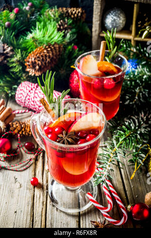 Traditional Christmas Mulled wine, grog or hot spicy sangria cocktail, on old rustic wooden table with christmas decorations and fir tree branches cop Stock Photo