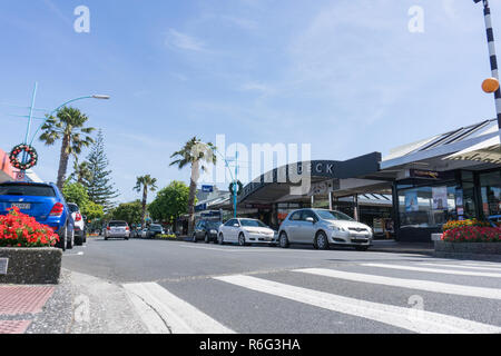 TAURANGA NEW ZEALAND - JANUARY 10 2018; Maunganui Road  view at low angle from pedestrian crossing with street  vehicles and buildings . Stock Photo