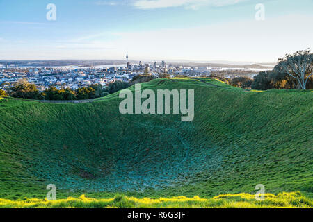 Auckland city skyline beyond frosty crater of Mount Eden just after sunrise Stock Photo