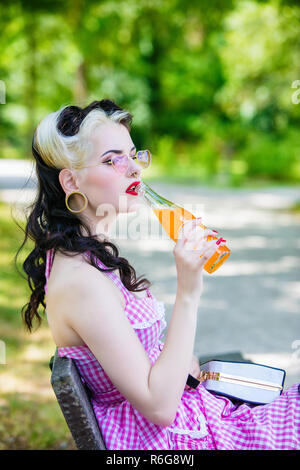 Portrait of a young Pin'Up in profile drinking a soda Stock Photo