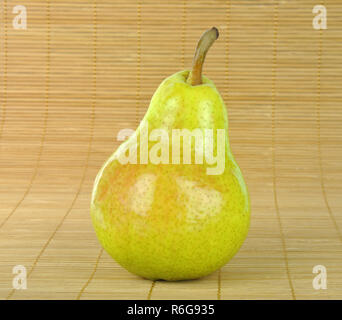 Green pear on bamboo mat background Stock Photo