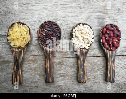 seed on wood spoon / grains or cereals seeds on wooden spoon various kinds of grains with red kidney bean , Job's tears , riceberry and brown rice on  Stock Photo