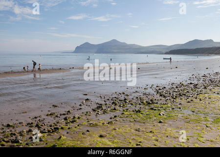 A family walking the tide line at Morfa Nefyn beach on the Llyn Peninsula in Wales Stock Photo