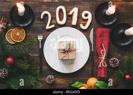 Table Setting Authentic New Year 2019 on rustic wooden table background. Minimalistic table setting top view Stock Photo