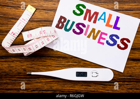 Conceptual hand writing text caption showing Small Business. Business concept for Family Owned Company written on sticky note paper on wood background. Meter and thermometer for fitness subject. Stock Photo