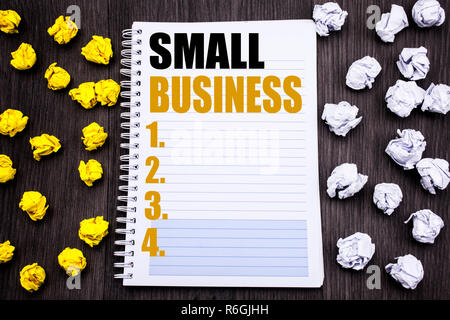 Conceptual hand writing text caption showing Small Business. Business concept for Family Owned Company Written on notepad note notebook book wooden background with sticky folded yellow and white Stock Photo
