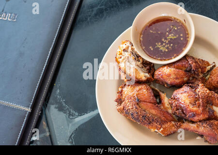 Fried chicken with spicy source in Thai menu style is served ready to be eaten. Stock Photo