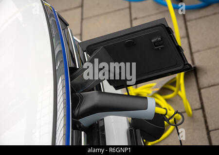 Recharging of an an electric car with a plug and cable Stock Photo