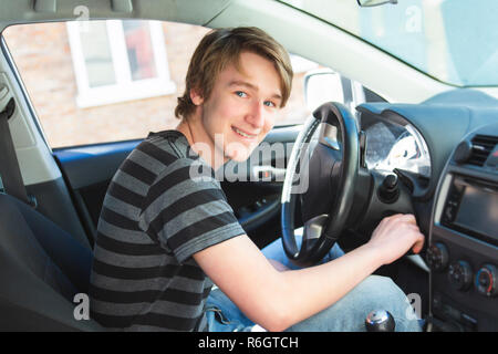 Teenage boy and new driver behind wheel of his car Stock Photo