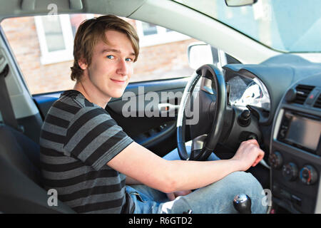 Teenage boy and new driver behind wheel of his car Stock Photo