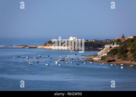 View of Vila Nova de Milfontes from N393 road bridge over the Mira River to the town and Praia do Farol beach with the Atlantic ocean behind. Stock Photo