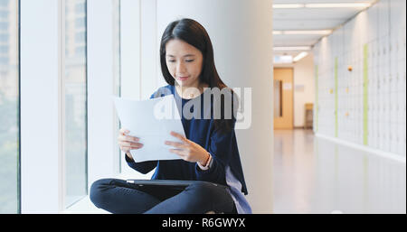 Woman reading on paper note in university campus Stock Photo