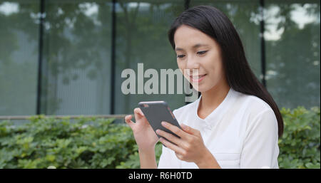 Young woman use of mobile phone in city Stock Photo