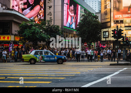 People waiting for a green light so the can cross a street in Hong Kong. Stock Photo