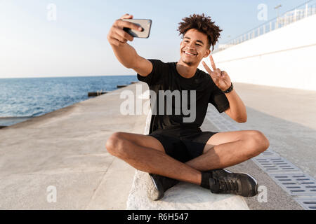Happy young african sportsman at the beach, taking a selfie Stock Photo