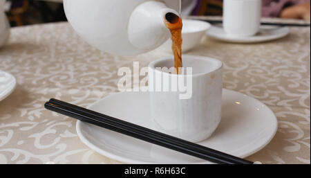 Pouring hot tea in mug at chinese restaurant Stock Photo